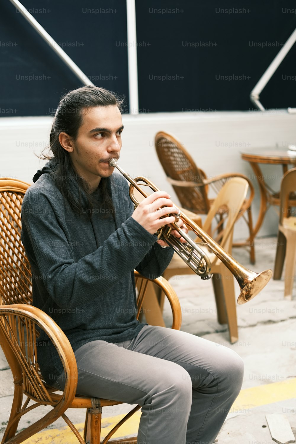 a man sitting on a chair playing a trumpet