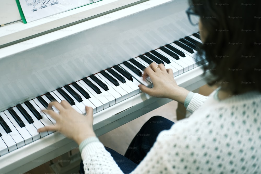 a woman is playing a piano with her hands