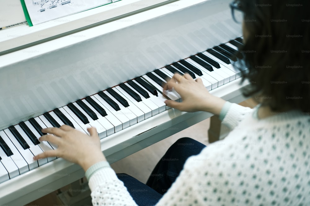 uma mulher está tocando um piano com as mãos