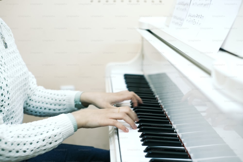 a woman sitting at a piano playing the piano