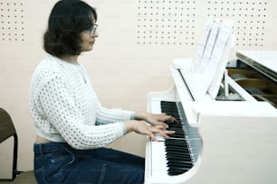 uma mulher sentada em um piano tocando um instrumento musical