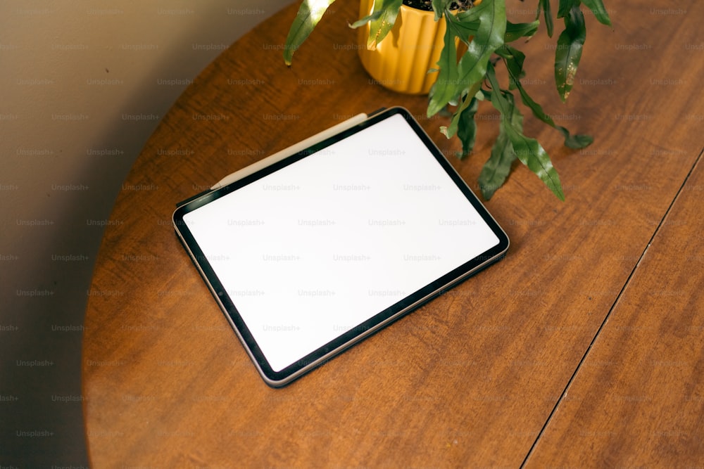 나무 테이블 위에 앉아 있는 태블릿 컴퓨터