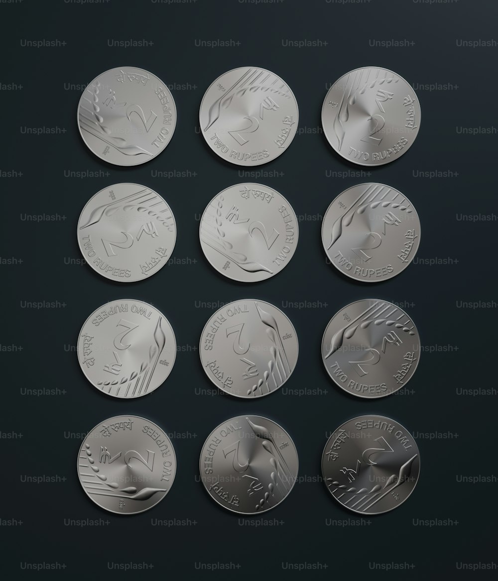 a set of six silver coins on a black surface