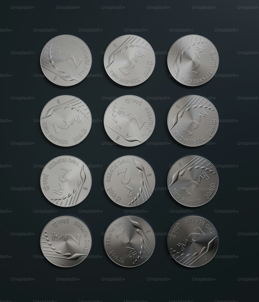 a set of six silver coins on a black surface