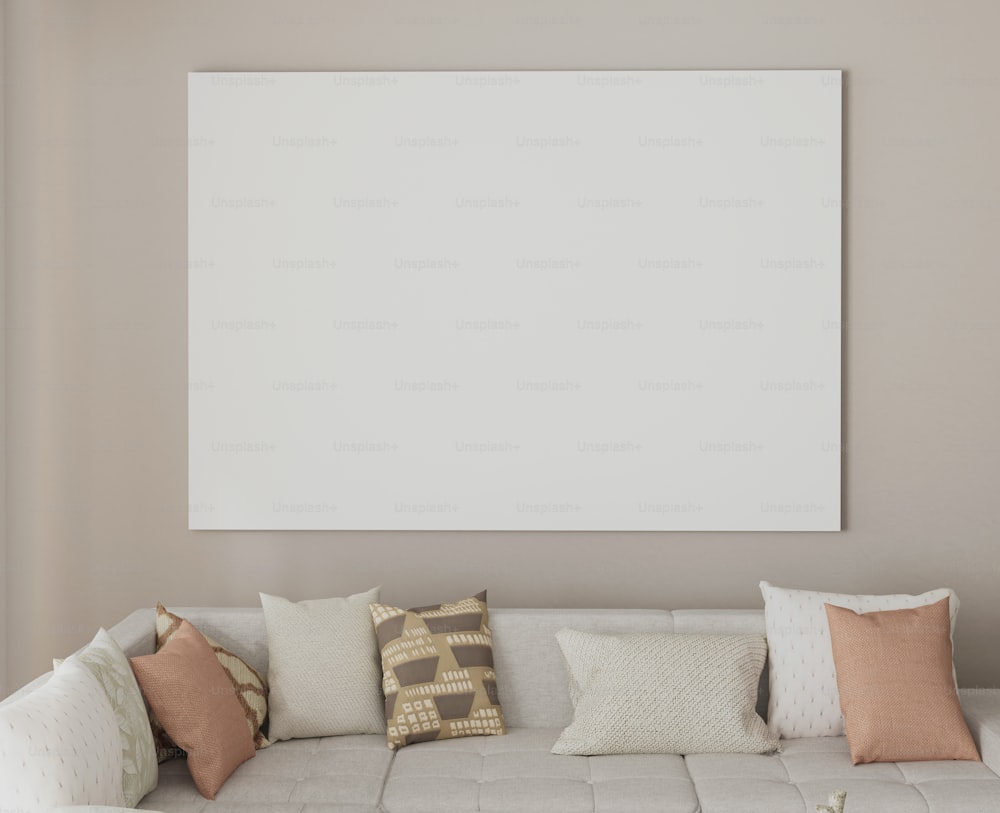 uma sala de estar com um sofá e um grande quadro branco na parede