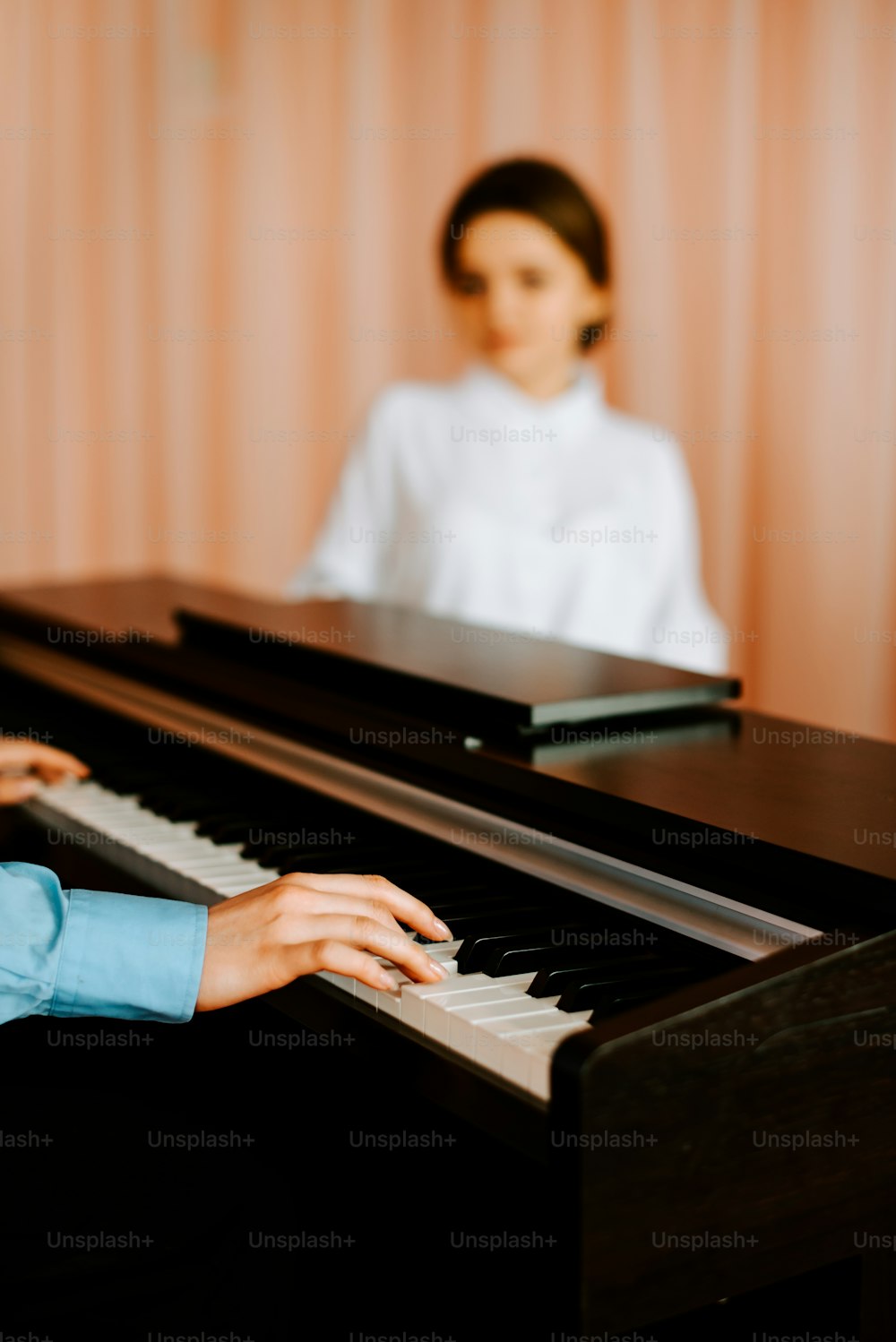 ピアノの前に座って歌を弾く女性