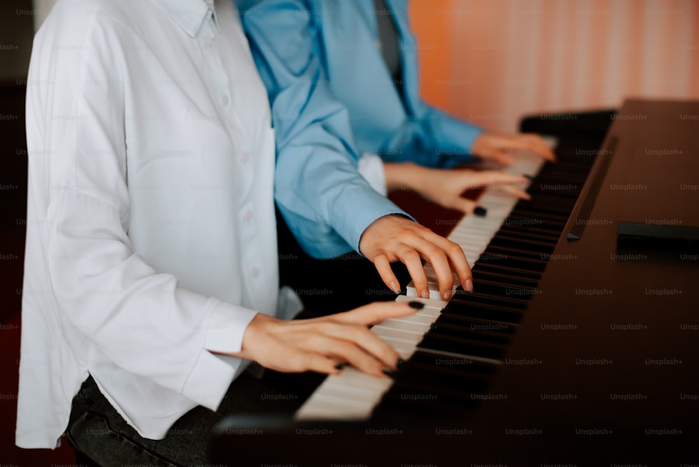 a man and a woman are playing the piano