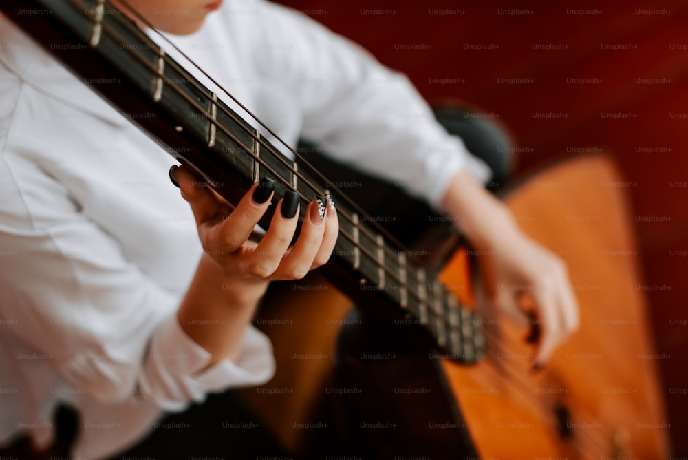 a woman holding a guitar in her hands