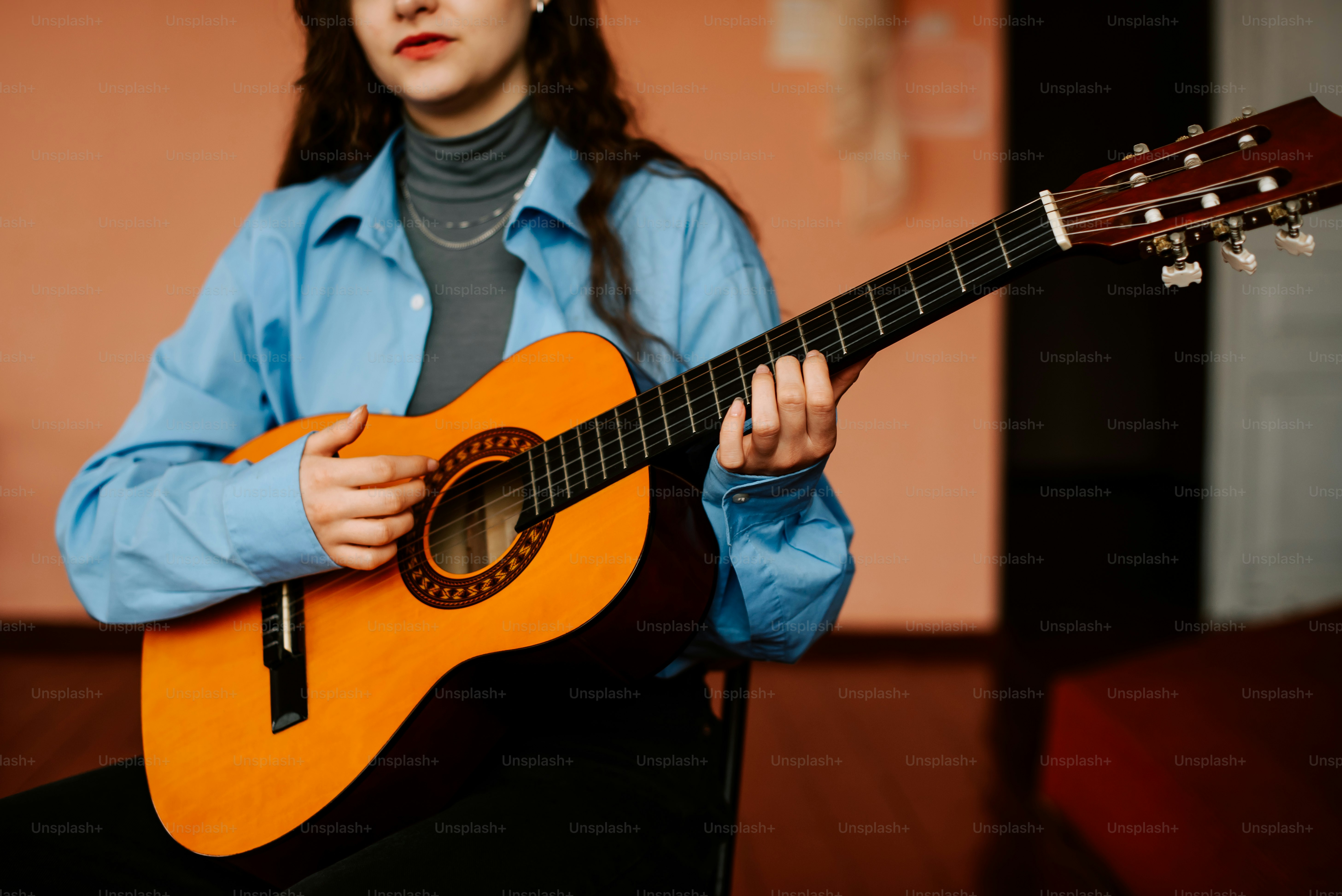 a woman sitting in a chair holding a guitar