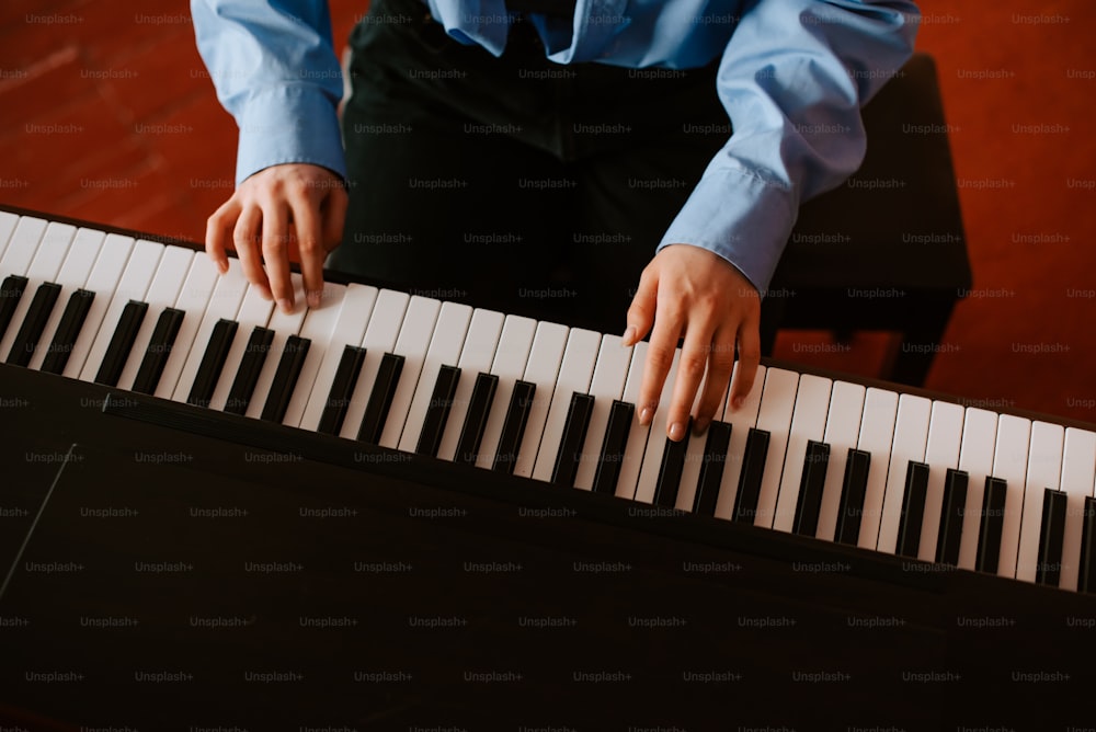 a man in a blue shirt is playing a piano