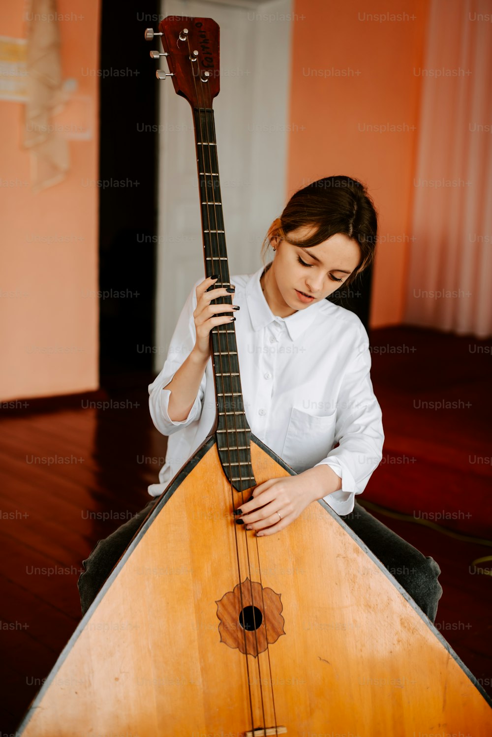 a woman holding a wooden instrument in her hands