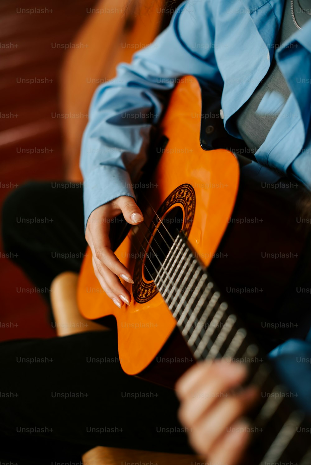 a man sitting down playing a guitar