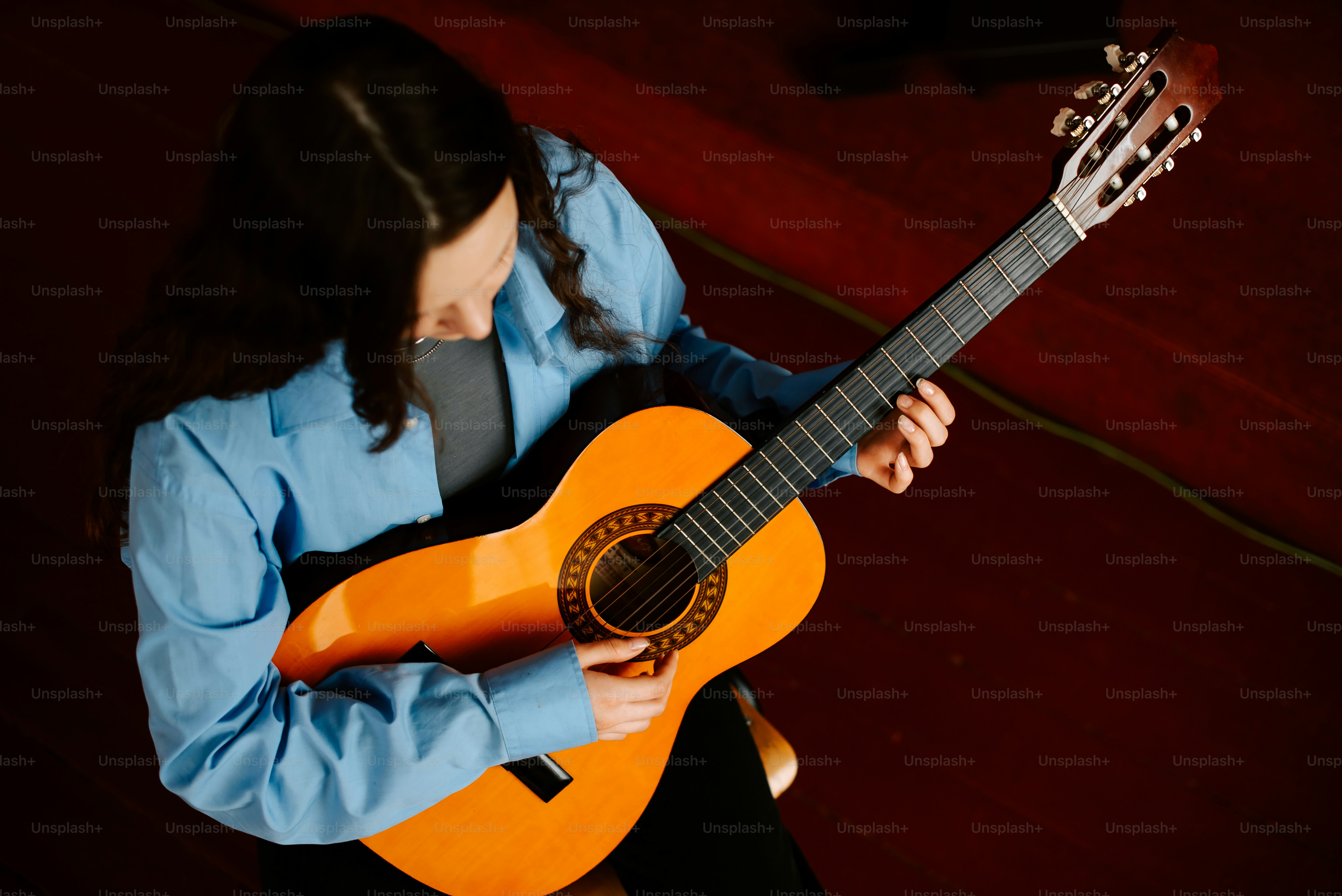 Una mujer tocando una guitarra en una habitación