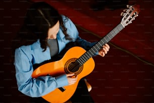 a woman playing a guitar in a room