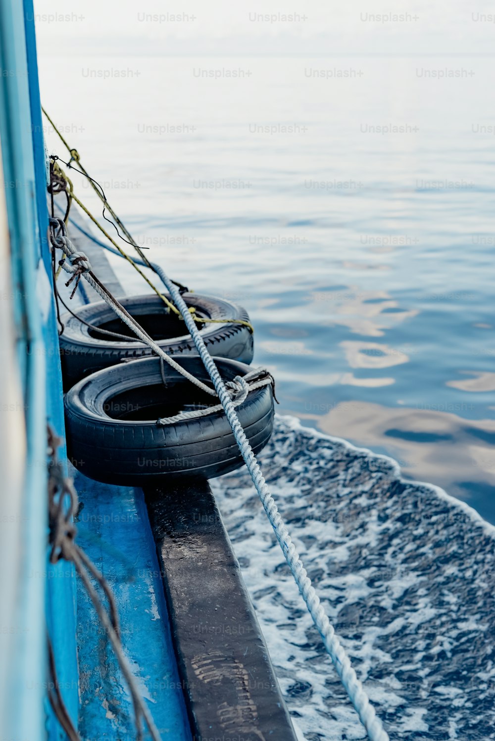 two tires are tied to the side of a boat