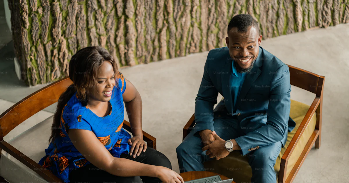 Young African businesspeople collaborating with a digital tablet in an office lounge