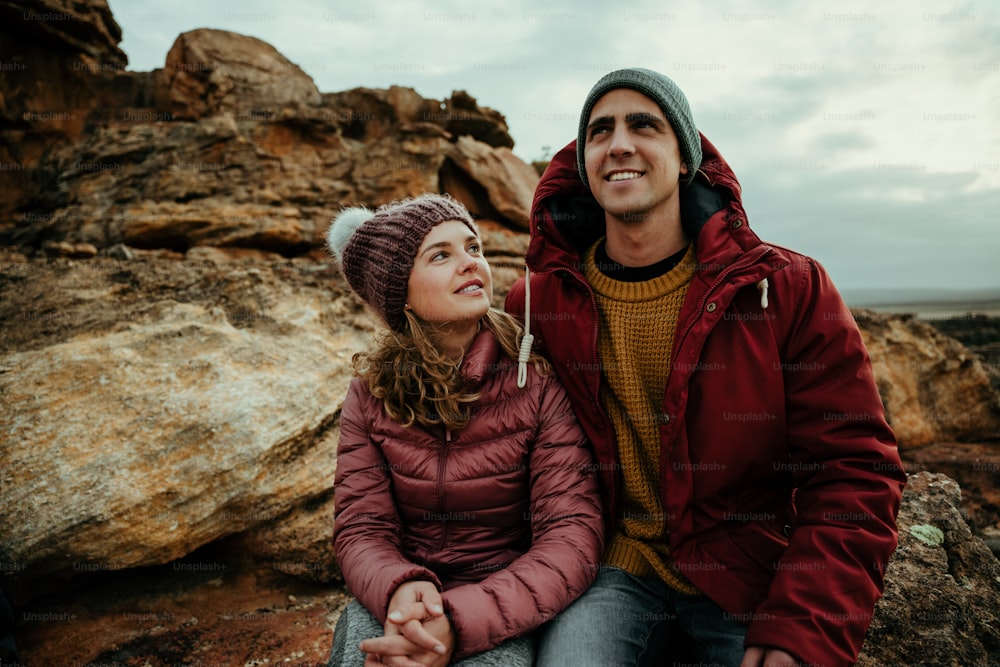 Namorada caucasiana e namorado sentado na montanha sorrindo se apaixonando. Foto de alta qualidade
