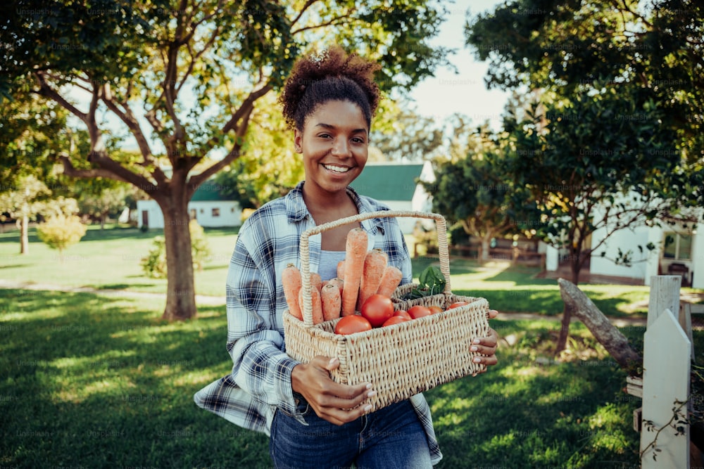 Mixed race female walking through farm village smiling looking happy after picking fresh vegetables from garden on beautiful sunny day . High quality photo