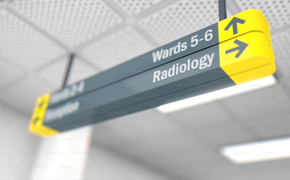 Un letrero direccional del hospital montado en el techo que destaca el camino hacia la sala de radiología - renderizado 3D