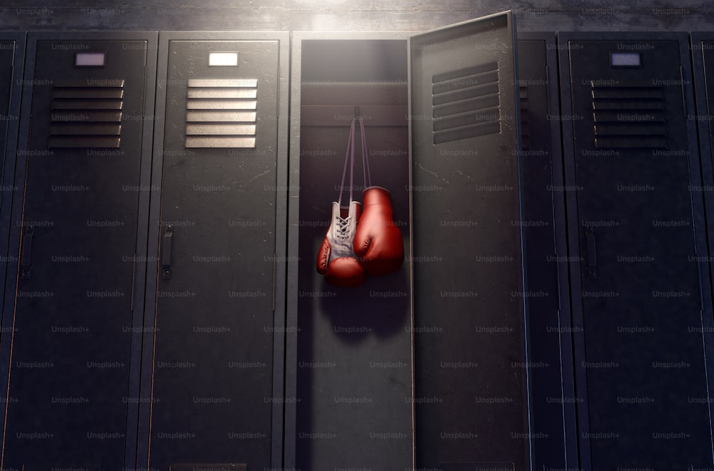 A row of metal gym lockers with one open door revealing that it has a pair of boxing gloves hanging up inside - 3D render