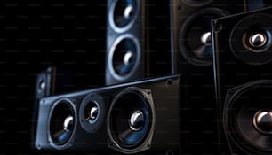 A modern surround sound speaker arrangment on a dark backlit studio background - 3D render