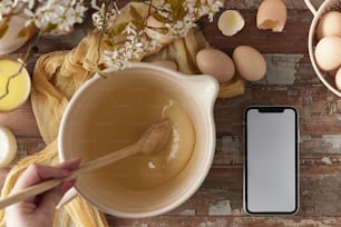 a wooden table topped with a bowl of liquid and eggs