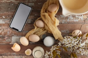 a cell phone sitting on top of a wooden table next to eggs