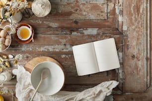 an open book on a table next to a bowl of eggs