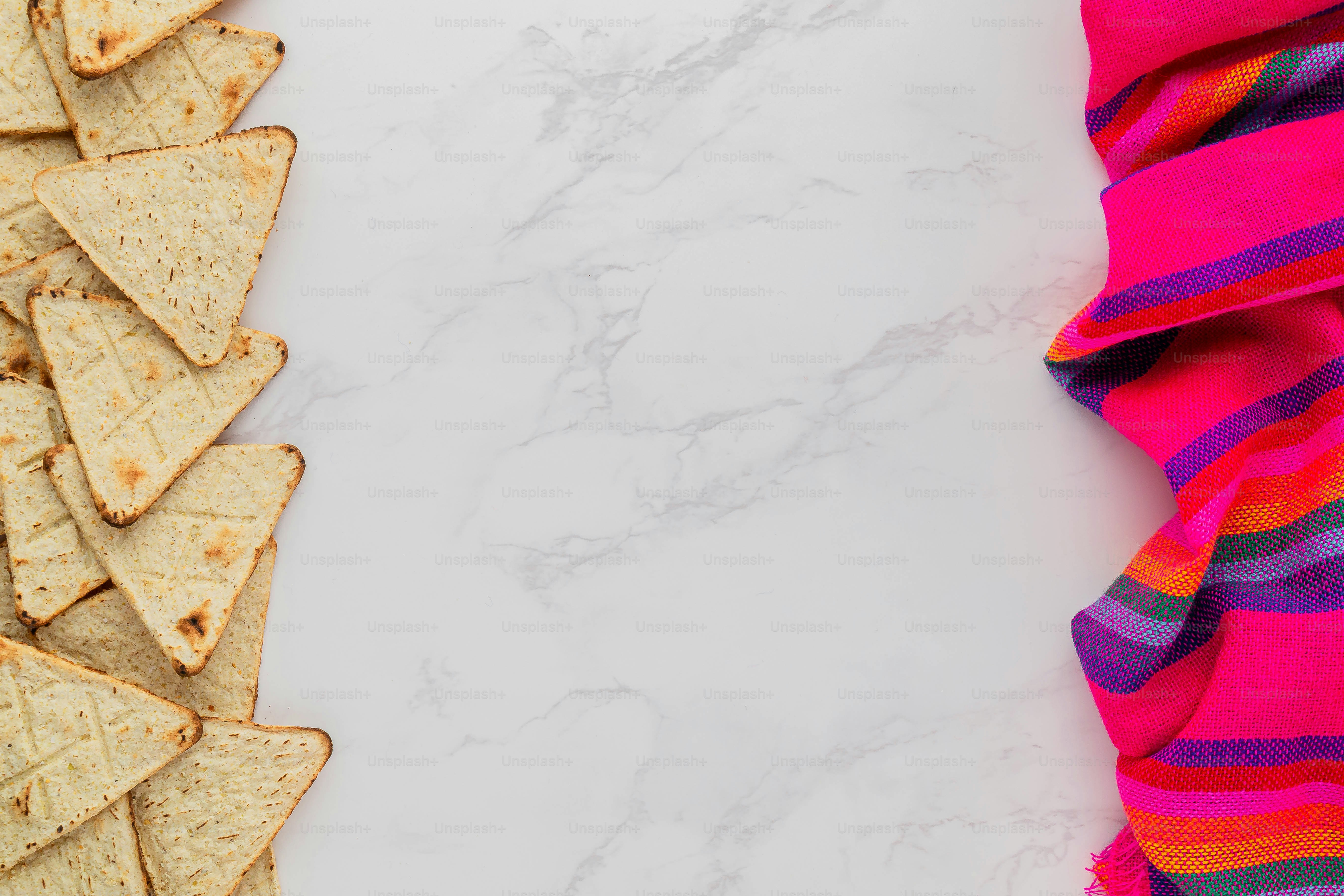 Un montón de chips de tortilla encima de un mostrador blanco