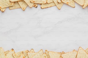 Tortilla-Chips auf weißem Marmorhintergrund angeordnet