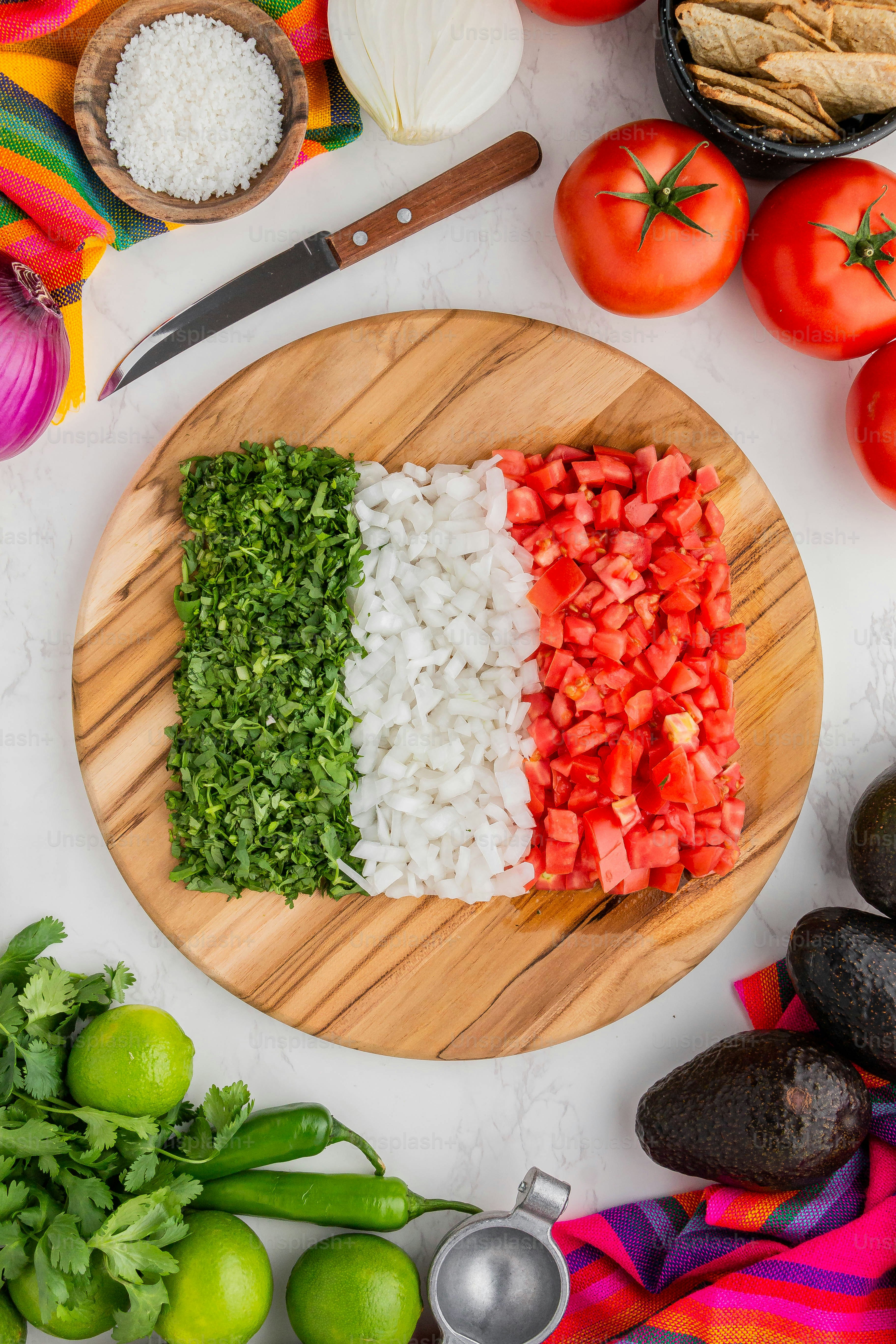 una tabla de cortar de madera cubierta con verduras en rodajas