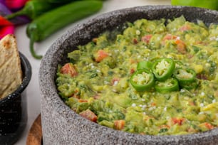 a bowl of guacamole and a bowl of tortilla chips