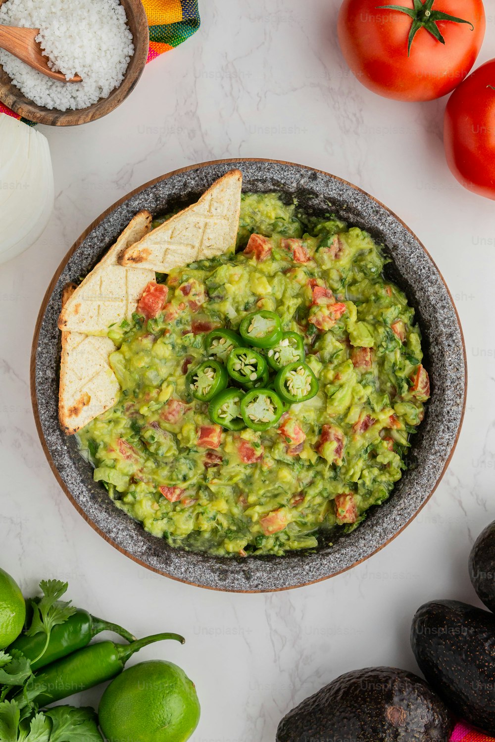 a bowl of guacamole with tortilla chips