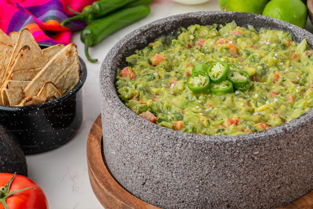 a bowl of guacamole and a bowl of tortilla chips