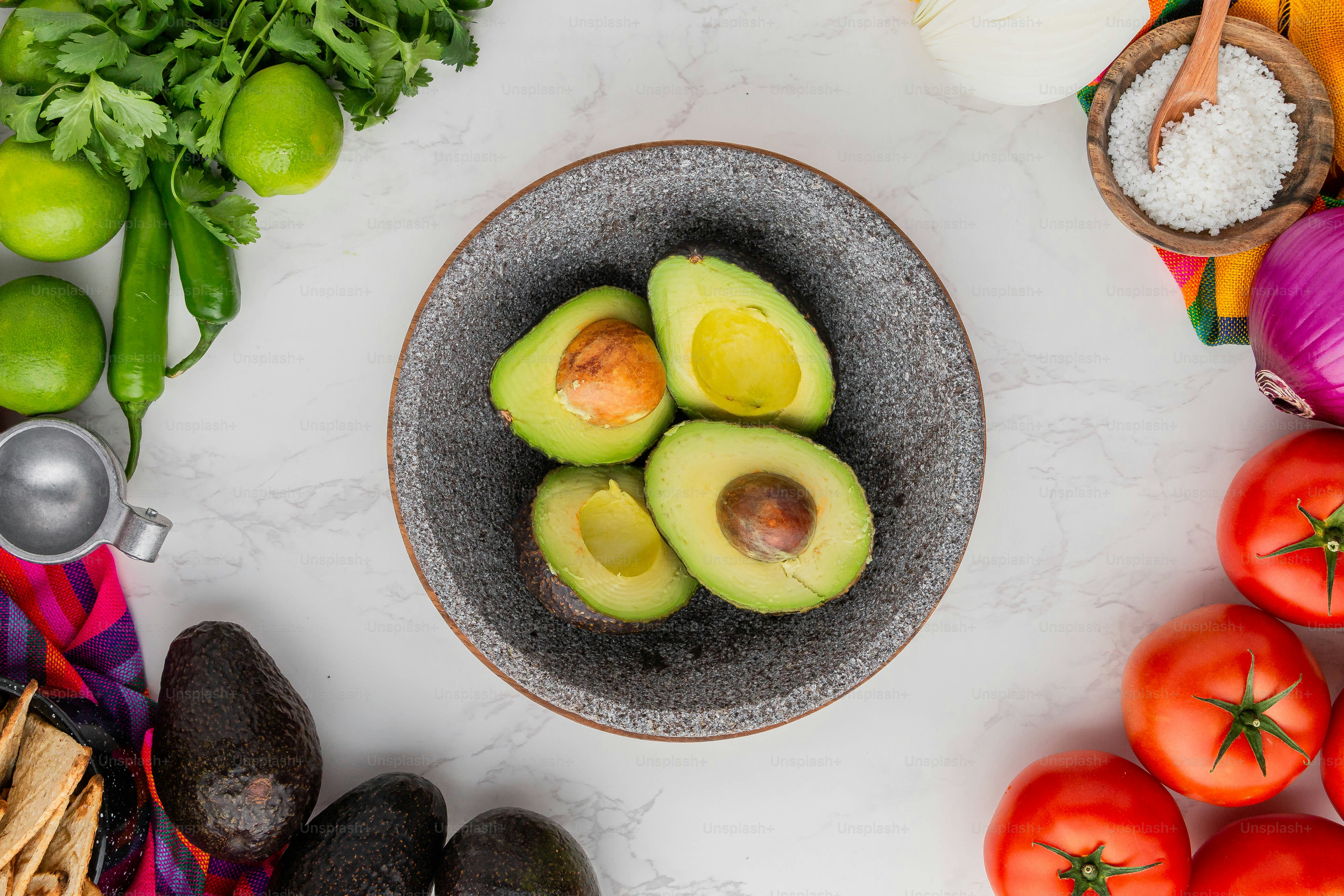 aguacates en un bol rodeado de otras verduras