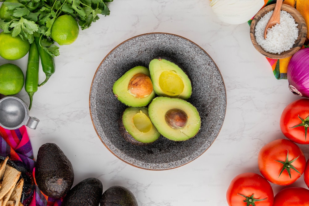 avocados in a bowl surrounded by other vegetables