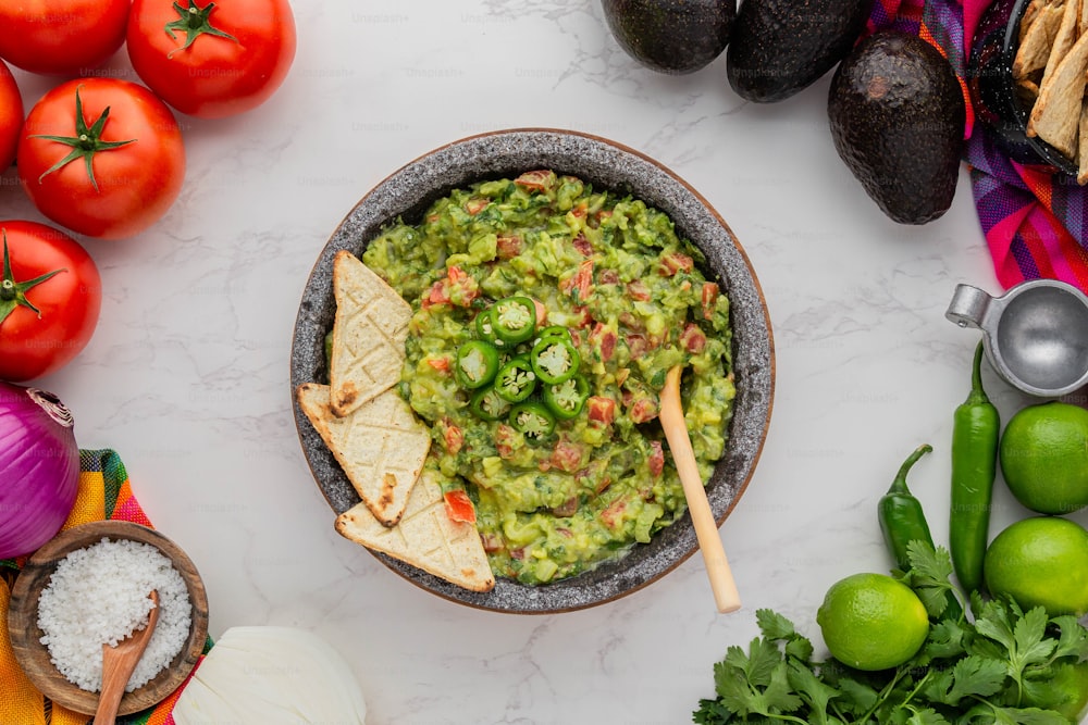 a bowl of guacamole with tortilla chips