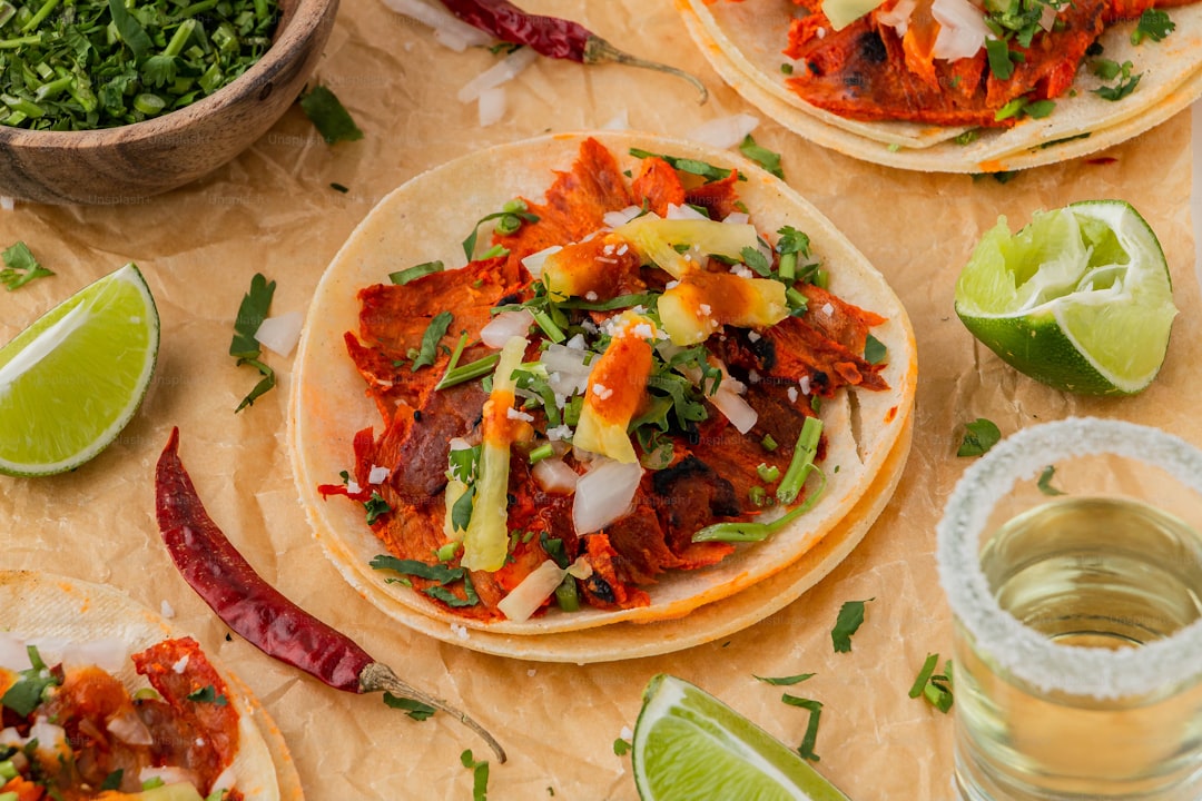 a table topped with three tacos covered in toppings