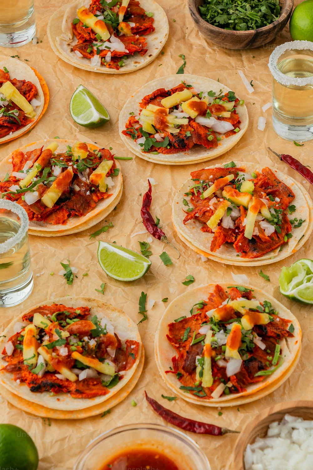 uma mesa coberta com muitos tacos cobertos de coberturas