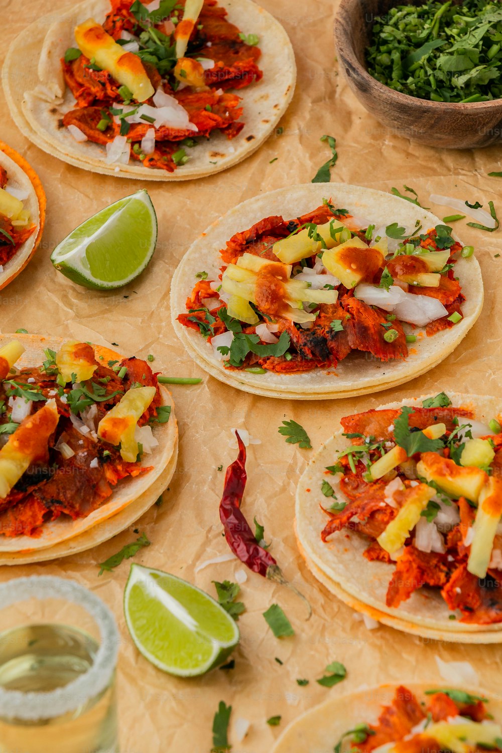 a table topped with lots of tacos covered in toppings