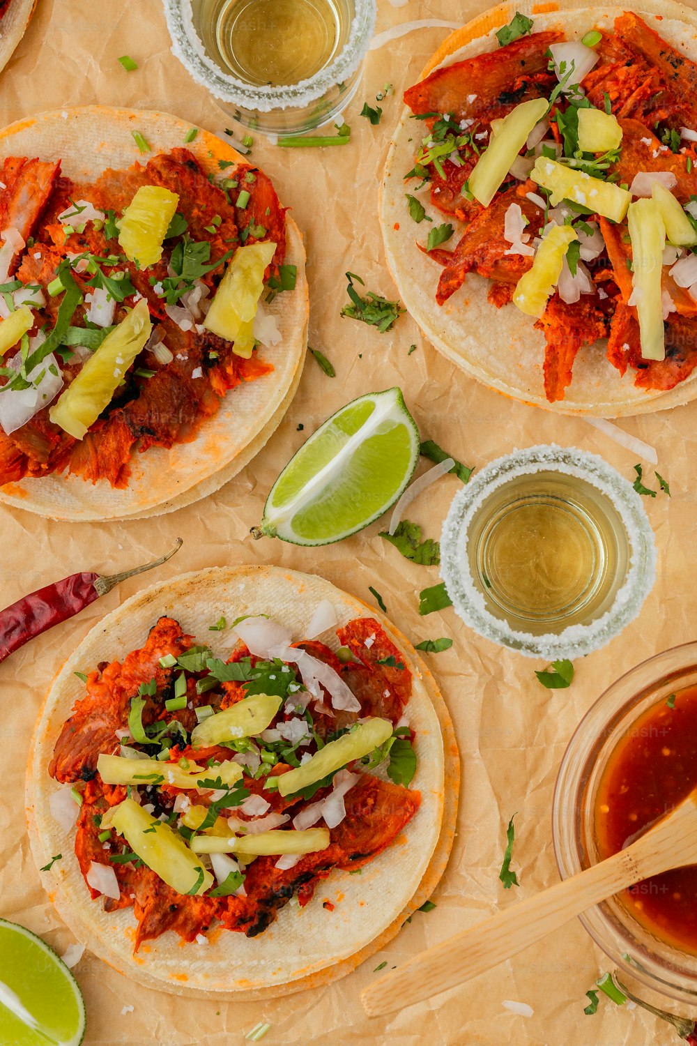 a table topped with three tacos covered in toppings