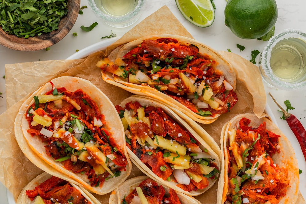 ein Teller Tacos mit Salsa und Limetten