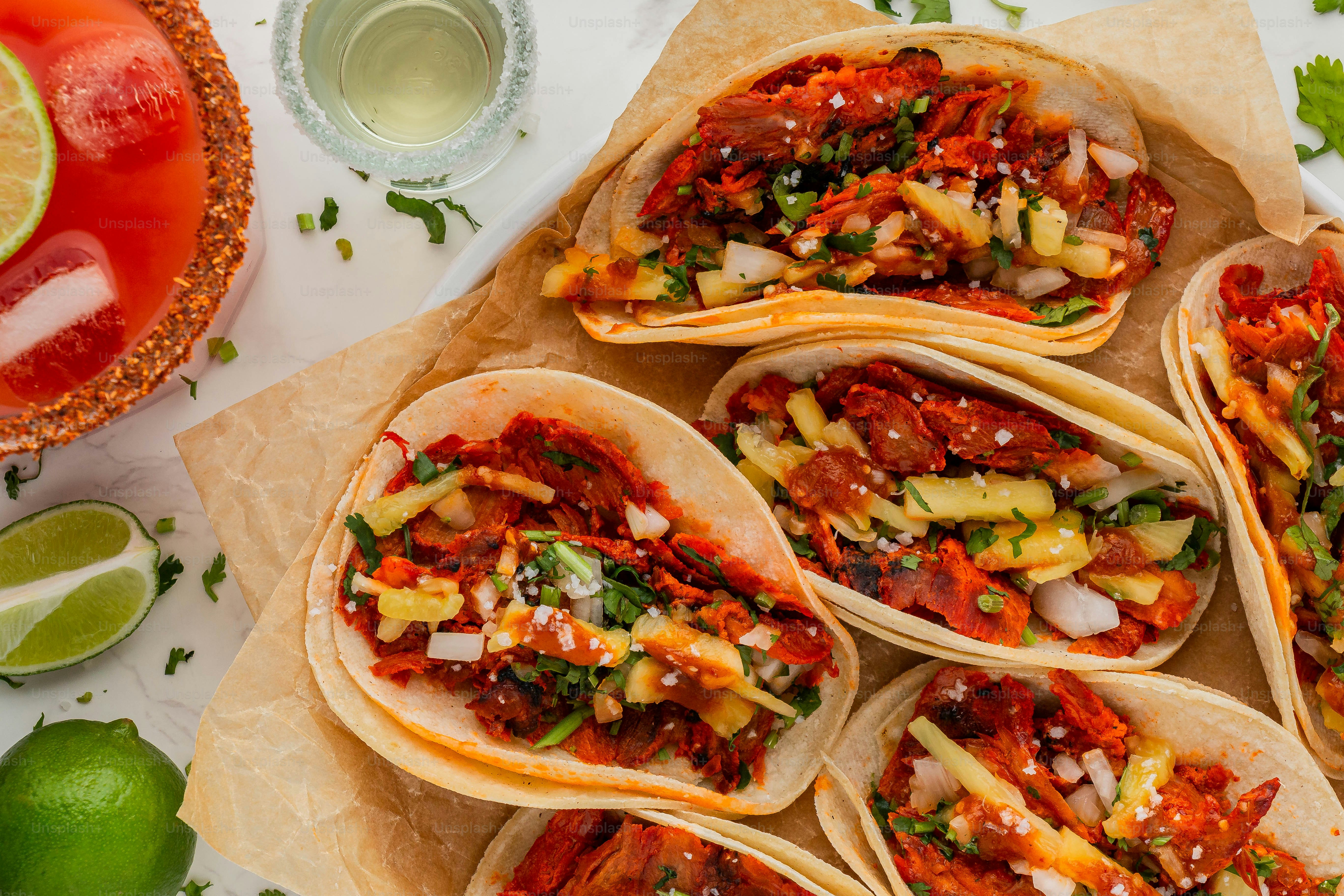 a plate of tacos on a table with limes