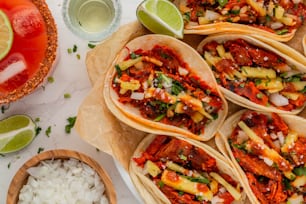 une table garnie de beaucoup de tacos recouverts de sauce