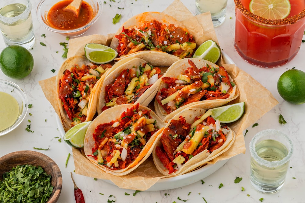 eine Platte mit Tacos mit Salsa und Limetten