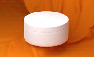 um recipiente branco sentado em cima de um pano laranja
