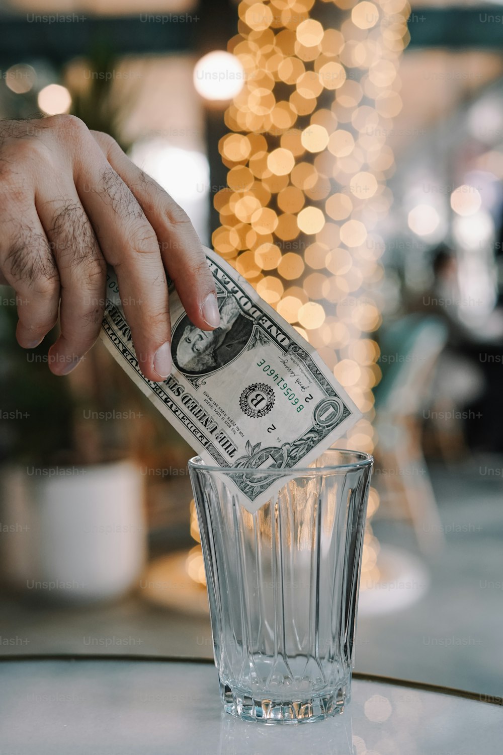 a person putting money in a glass of water