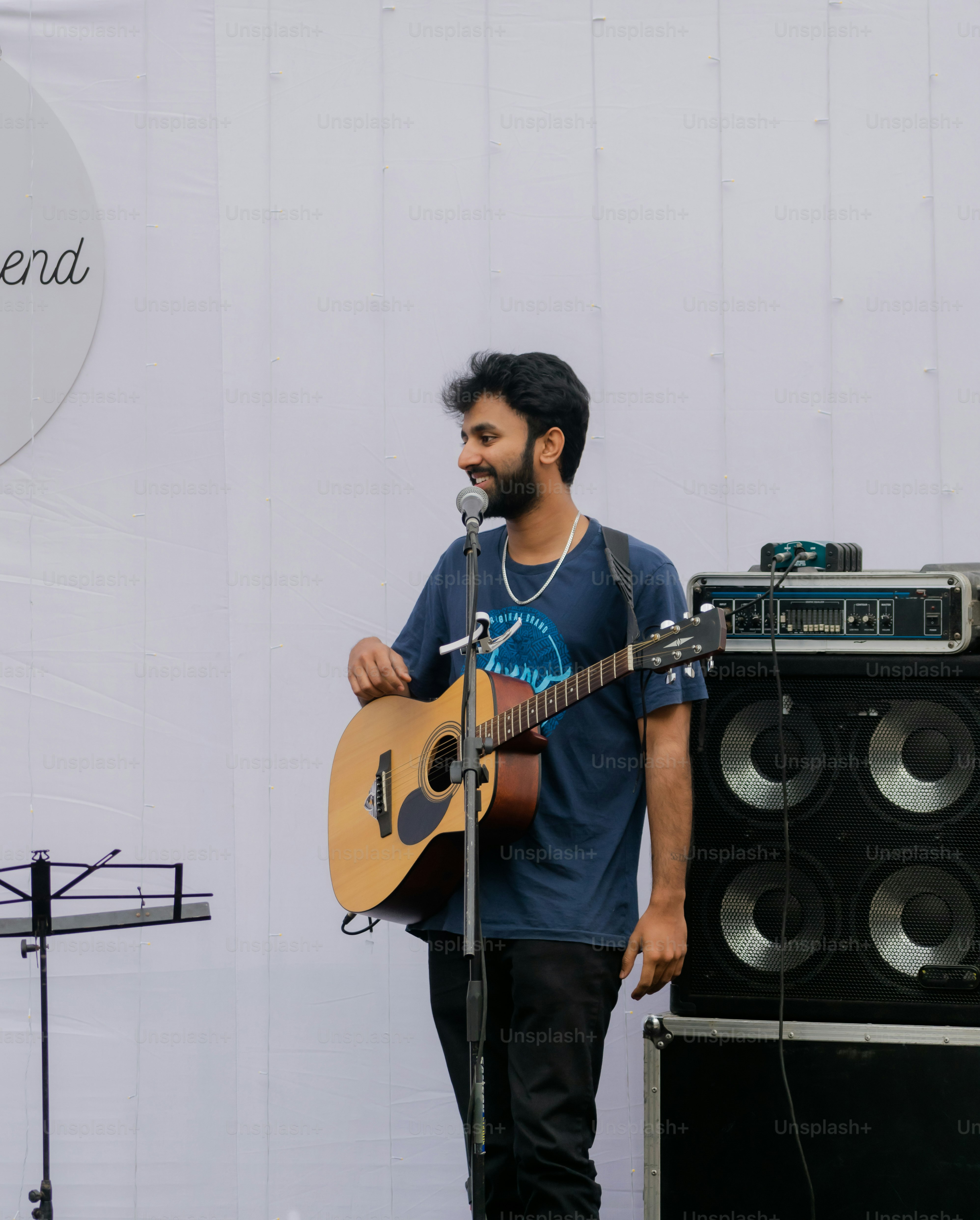 a man standing next to a guitar on a stage