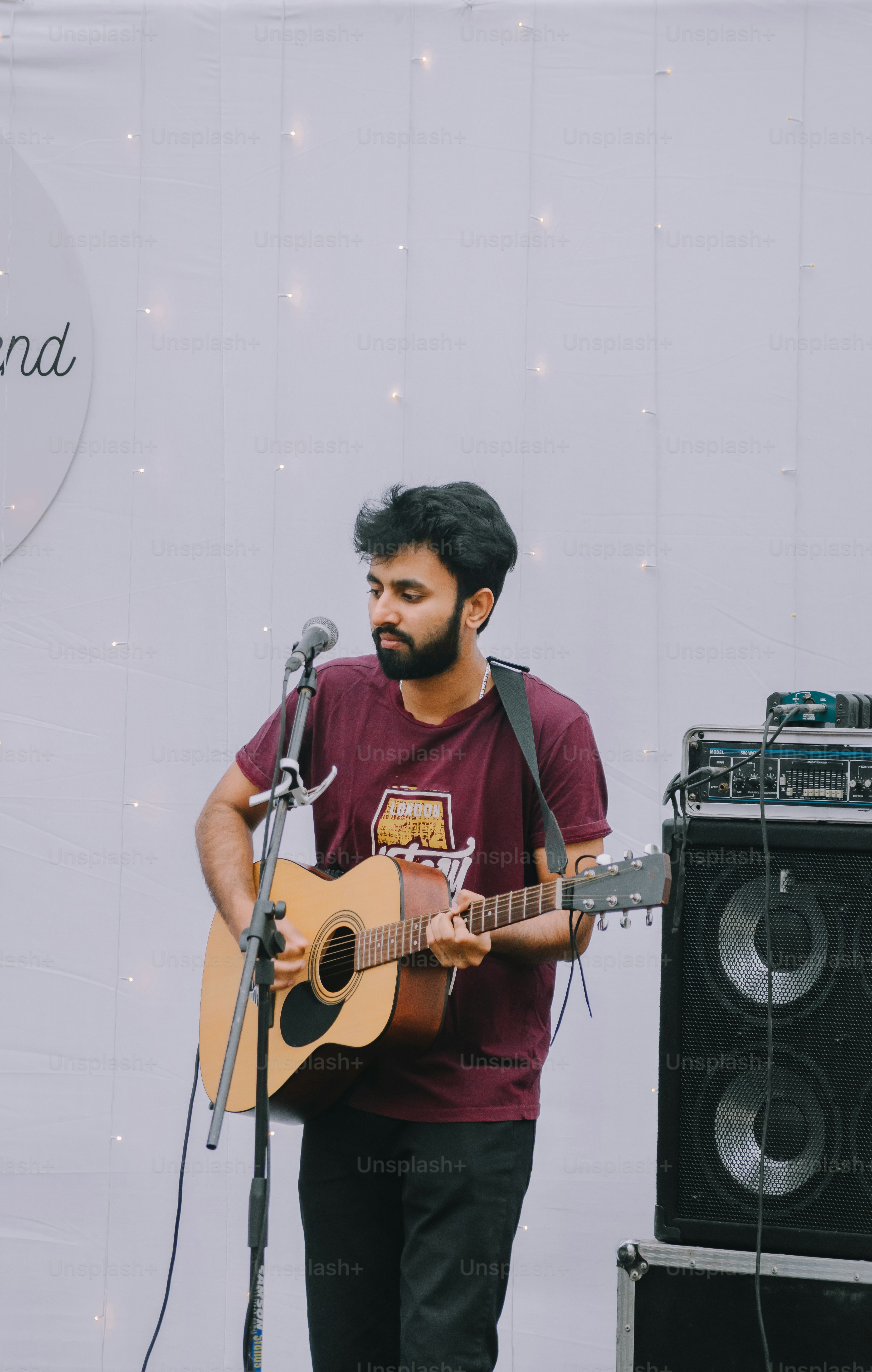 a man playing a guitar in front of a microphone