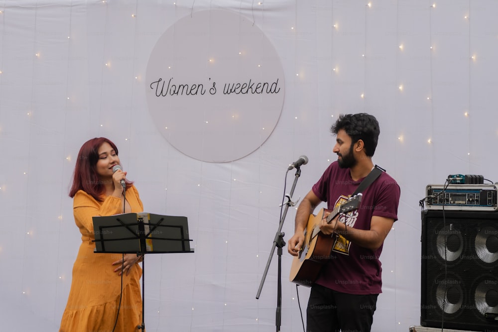 Un hombre y una mujer cantando en un micrófono